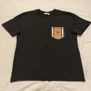 Svart burberry t-shirt  - Säljer en snygg svart burberry t-shirt i storlek S men kan även passa M, den är andvänd väldigt få gånger på sommaren och bara tvättat den en gång, priset ligger bara på 199 kr, hör av er vid intresse!