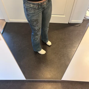 Blå jeans - Snygga blå jeans med unikt drakmotiv på låret. Helt utan defekter! Så snygga och verkligen one of a kind