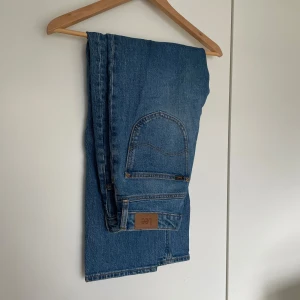 Blå jeans från Lee - Snygga blå jeans från Lee i modellen Carol. Tillverkade av ekologisk bomull, dessa jeans har en klassisk design med fem fickor och en bekväm passform. Perfekta för en avslappnad stil.