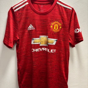 Manchester United fotbollströja  - Säljer en Manchester United fotbollströja från Adidas. Använd fåtal gånger men fint skick! Tröjan är i Dam storlek men borde även passa för män.