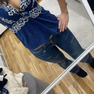 Mörkblåa slitna bootcut jeans - Snygga mörkblå bootcut jeans med slitningar. De har en klassisk femficksdesign och en bekväm passform. Perfekta för en avslappnad stil. De är omsydda till lågmidjat, därav en tajtare passform💕💕