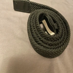 Svart flätat bälte - Snyggt svart flätat bälte med silverfärgat spänne.  Från jack and Jones | 105 cm | Hör av er vid funderingar :)