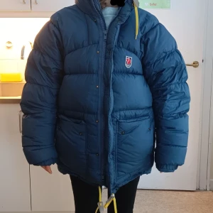 Fjällräven dunjacka Expedition Down XS - Fin blå dunjacka från Fjällräven i modellen Expedition Down. Storlek XS men passar S och M beroende på hur man vill att den ska sitta.