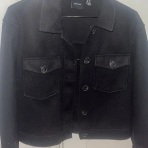 Svart kort kappa - Svart kort kappa från vero Moda. Andvönd endast några enstaka gånger. Storleken m men passar mig bra som är en storlek s i vanliga fall.