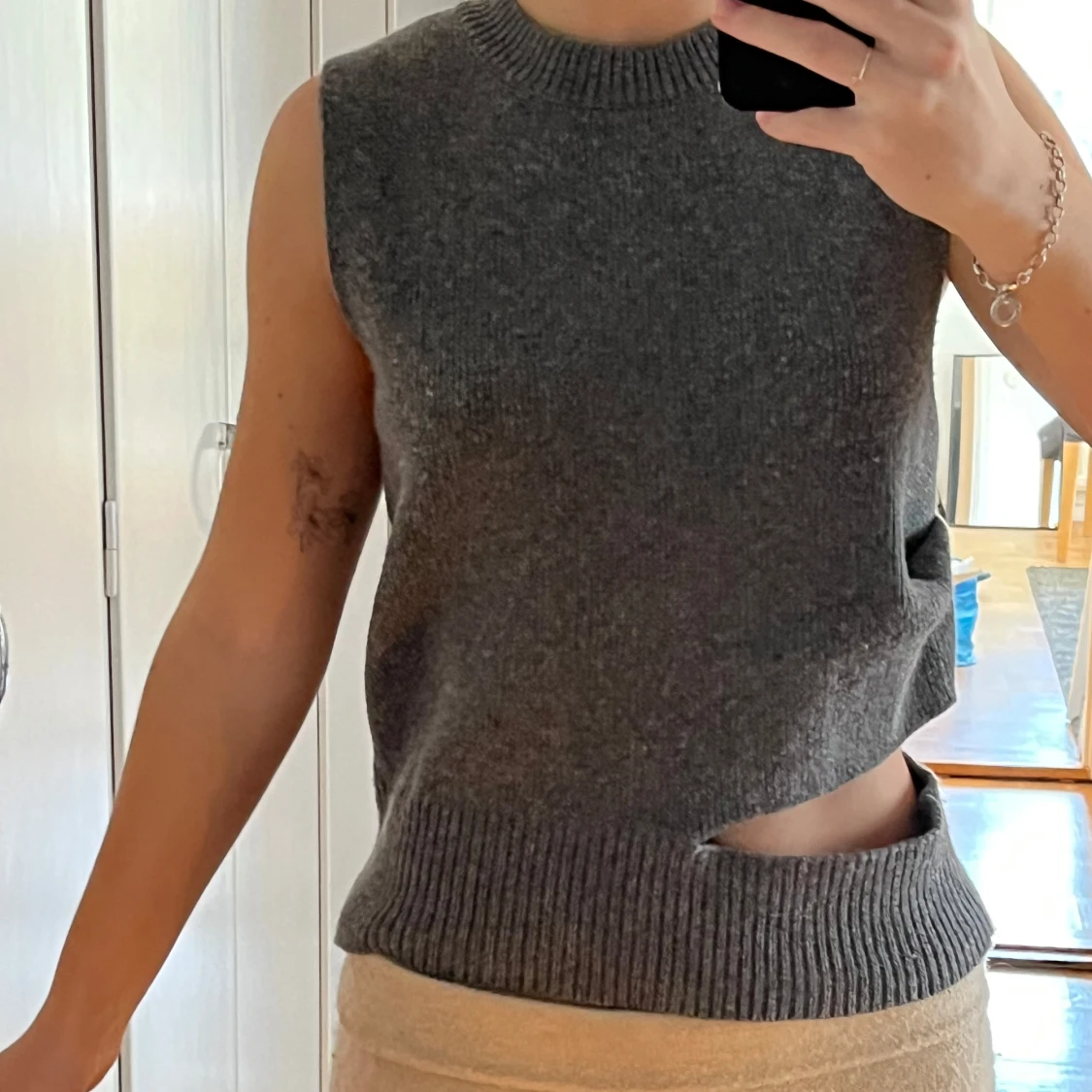 Stickad grå ärmlös topp med asymmetrisk design - 1