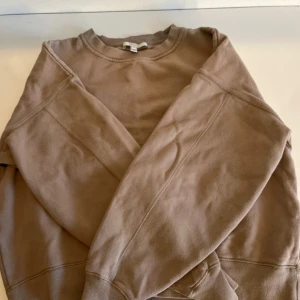 Beige sweatshirt från Dagmar - Säljer en stilren beige sweatshirt från Dagmar. Tröjan har en klassisk rund halsringning och långa ärmar. Perfekt för en avslappnad look.