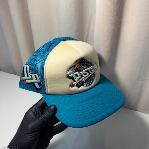 Mitchell & Ness keps - Snygg keps i blått och vitt med broderad logga framtill. Kepsen har ett nätmaterial baktill för ventilation och justerbar passform. Perfekt för en avslappnad stil.