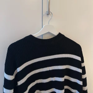 Svart och vit randig stickad tröja - Säljer en svart och vit randig stickad tröja med rund hals. Tröjan har långa ärmar och är perfekt för kyligare dagar. En klassisk och stilren design som passar till mycket. Perfekt för dig som gillar en tidlös look! Skriv vid frågor eller intresse 💞