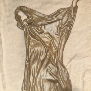 Champagnefärgad balklänning  - En sååå fin balklänning. Klänningen har en glittrig finish och en draperad halslinje. Klänningen är hellång till golvet. Super fin verkligen, använd en gång 🌸🌸🥹