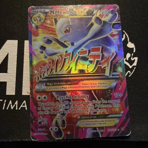 Mega Mewtwo EX Pokémonkort - Säljer ett Mega Mewtwo EX Pokémonkort med Psychic Infinity-attack. Kortet har en holografisk design med japansk text och är en del av en samling. Perfekt för samlare eller spelare som vill förstärka sin kortlek.