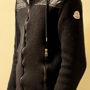 Moncler Cardigan  - Cardigan från Moncler med dragkedja och quiltade detaljer på axlar och huva. Den är i väldigt fint skick och är sparsamt använd.