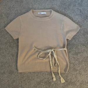 Beige stickad topp från Zara - Supper söt och fin tröja från Zara som inte säljs längre. Tröjan har en knytning i midjan som ger en fin detalj och är tillverkad i ett mjukt material. Perfekt för en avslappnad look💗Den är en blandning av rosa och beige. Använts fåtal gånger och därför i ny skick. Väldigt efterfrågad och kan kläs till vad som helst💗 Är i storlek S men passar XXS-S. Pris kan gärna diskuteras💗💗 Köparen står för frakten⚠️⚠️