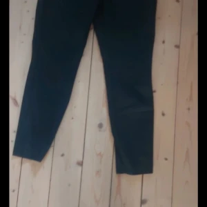 Svarta byxor - Snygga svarta byxor med en tight passform. Perfekta för en stilren look. Byxorna har en rak design och är tillverkade i ett bekvämt material.