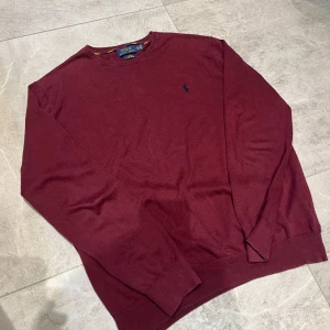 Stickad Ralph Lauren - Tja, säljer nu en riktigt snygg stickad Ralph Lauren tröja i vinrött. Står storlek XL men krympt så passar M/L. Bevis på att den är äkta finns på sista bilden. Öppen för att diskutera pris!