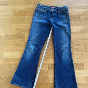 Blå jeans från Unionbay Bootcut lågmidjade vintage - Säljer ett par snygga blå jeans från Unionbay. De har en bootcut-stil och är tillverkade i klassiskt denim. Jeansen har en låg midja och är perfekta för en avslappnad look. De har också en dragkedja och knappar framtill. Se bild för mått, liten defekt på sista bilden som knappt syns om man inte kollar noga även lite slitage längst ner men bara snygggtttt💋💋💋💋Från 2000 talet😻står storlek 3/30 i byxorna men passar XS-s se bild för mått