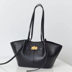 midi long strap bag - Elegant svart axelväska i skinn från Gina tricot med en stilren guldfärgad låsdetalj. Väskan har långa remmar för bekväm bärning och en modern design som passar till många tillfällen. Den är använd en gång endast!