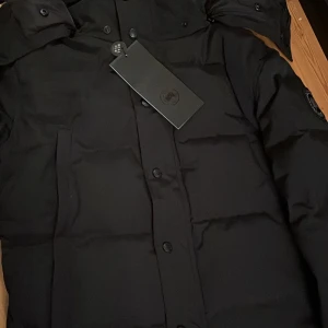 Canada goose Wyndham parka black label - Jackan är i nyskick och är helt fel fri. Jackan är ett perfekt val för vintern eftersom den är såpass varm. Säljer den pågrund av att den är för stor för mig. Priset är inte hugget i sten!