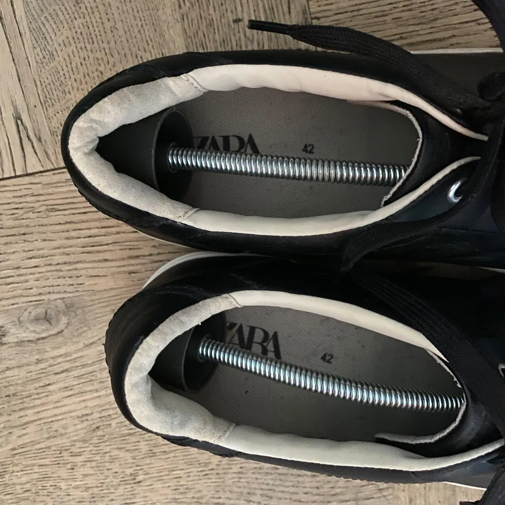 Säljer ett par stilrena svarta sneakers från Zara i storlek 42. Skorna är i nyskick, endast använt en gång under studenten.. Skor.