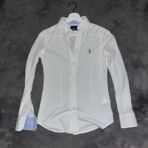  Ralph lauren skjorta - Säljer nu denna knit oxford Ralph lauren skjortan. Storleken är xs men är väldigt tajt även för det. Vit med blårandigt mönster på insidan. Så gott som nyskick. Hör av dig vid minsta fråga!