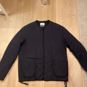 Svart jacka från Filippa K - Str- 46 men snarare 48. Säljer en stilren svart jacka från Filippa K. Den har en enkel design med dragkedja framtill och två stora fickor. Perfekt för höst och vår, och passar till de flesta outfits. Jackan är i nyskick. Nypris 1500:-