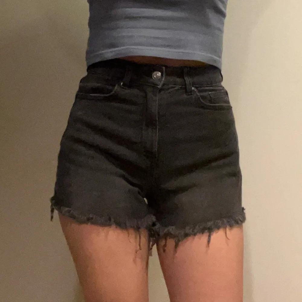 Säljer ett par svarta jeansshorts från H&M Divided. De är högmidjade med en cool fransig kant längst ner. Perfekta för en avslappnad sommarlook! . Shorts.