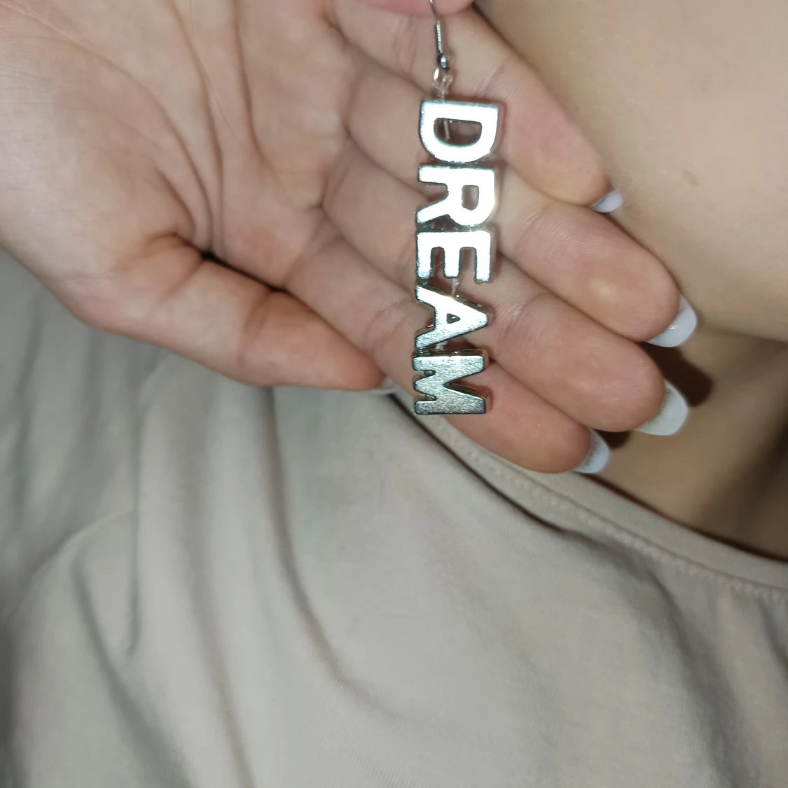 Silvriga örhängen med texten DREAM - 90