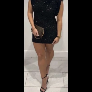 Svart glittrig klänning - Snygg svart klänning med glittriga paljetter. Den är ärmlös och har en tight passform som framhäver figuren. Perfekt för en festkväll och speciellt nu till nyår! Aldrig använt(första bilden är lånad)