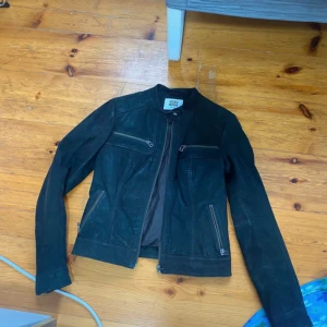 Svart skinnjacka från Miss Selfridge - Snygg svart skinnjacka från Miss Selfridge med dragkedjor på bröstet och sidorna. Jackan har en stilren design med långa ärmar och en tight passform. Perfekt för en cool och edgy look.