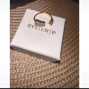 Guldring med röd och grön sten från Syster P - Elegant ring från Syster P med en iögonfallande röd sten.  Kan gå ner i pris. Köpt i mall för 999kr