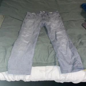 Grå jeans från Regular Clark - Säljer ett par grå jeans från Regular Clark. De har en klassisk femficksdesign med dragkedja och knapp framtill. Perfekta för en avslappnad stil. Jeansen är insydda vid benen så dem passar folk som är runt 160 cm. 