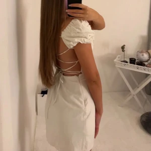 Vit klänning med puffärmar - Säljer en söt vit klänning med puffiga kortärmar och snörning i ryggen. Perfekt som studentklänning!