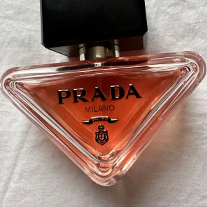Prada Paradoxe Intense Eau de Parfum 30 ml , knappt använd 2-3 gånger .Tyvärr ingen kartong  - Upptäck Prada Paradoxe Intense, en elegant och sofistikerad doft i en unik triangulär flaska. Den har en djup rosa färg och ett stilrent svart lock. Perfekt för den som vill ha en lyxig och modern parfymupplevelse.Använd knappt 2-3 gånger . Tyvärr ingen kartong . 