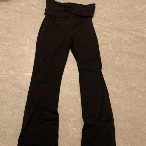 Svarta byxor med hög midja - Snygga svarta byxor med hög midja och bootcut-stil. Perfekta för en stilren look. Tillverkade i ett mjukt och bekvämt material som ger en skön passform.