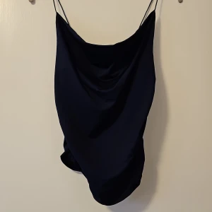 Svart topp från Shein - Snygg svart topp från Shein med tunna axelband. Perfekt för en stilren look. Tillverkad i 95% polyester och 5% elastan för en bekväm passform.