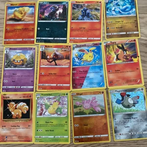 Samling av Pokémonkort - Stor samling av Pokémonkort med olika karaktärer som Numel, Deino,  Salandit, Froakie, Eevee, Cubone och många fler. Perfekt för samlare eller spelentusiaster som vill utöka sin kollektion. Kort från olika serier och generationer. Pris per pack av 12 styck 
