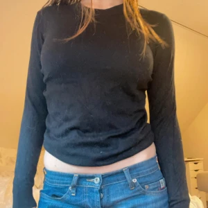 Svart långärmad tröja - Säljer en stilren svart långärmad tröja. Perfekt för en enkel och klassisk look. Tröjan har en normal passform och är tillverkad i ett mjukt material som känns skönt mot huden.
