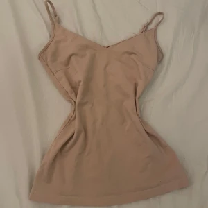 Beige vintage linnetopp - Säljer en stilren beige linnetopp med smala axelband och v-ringad design. Perfekt för varma dagar eller som lager under andra plagg. Skriv ifall du har någon fråga 💗