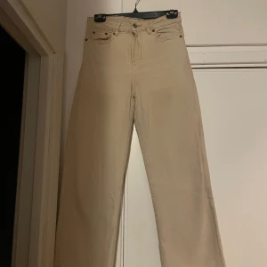 Beigea jeans  - Beigea jeans väldigt fina på små små gröna fläckar med färg men syns knapp