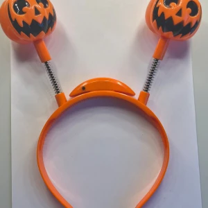 Orange diadem med lysande pumpor - Coolt orange diadem med två lysande pumpor på fjädrar. Perfekt för Halloween eller andra festliga tillfällen. Pumporna har ett skrämmande ansikte och lyser upp i mörkret för extra effekt. Från Liseberg 