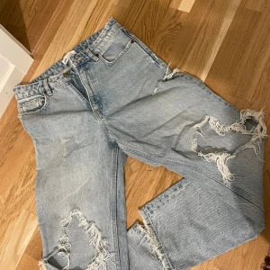 Ljusa jeans med slitningar från Zara - Säljer ett par ljusa jeans från Zara med coola slitningar på benen.