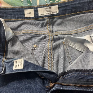 Blå flare jeans - Snygga blå flare jeans från berskha i storlek EUR 38. De har en klassisk femficksdesign och dragkedja. Perfekta för en avslappnad stil med en touch av retro.