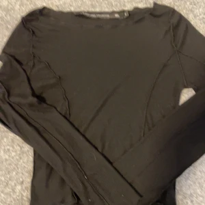 Svart långärmad tröja från lager 157 - Säljer en stilren svart långärmad tröja från lager 157. Tröjan har en enkel design med ribbade detaljer och är perfekt för en minimalistisk look. Passar bra till både jeans och kjol.