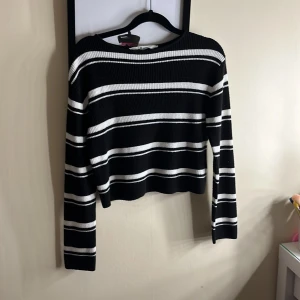 Svart och vit randig tröja från H&M - Säljer en svart och vit randig tröja från H&M. Tröjan har långa ärmar och är ribbad, vilket ger en skön och stilren look. Perfekt för en avslappnad stil. Den är väldigt kort i magen. Den är från barn avdelningen men skulle säga att storlek passar xxs-xs