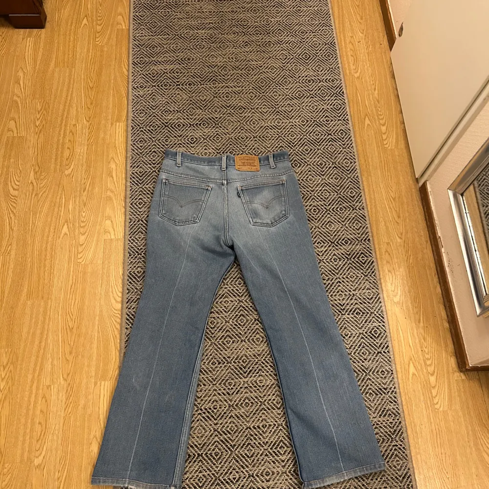 Säljer ett par klassiska Levi's 517 jeans i blå denim. De har en bootcut-stil och en snygg slitning på ena benet. Perfekta för en avslappnad look. Igentliga storleken är 34/30. Farkut & Housut.