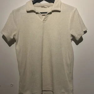 Beige frotté pikétröja - Säljer en stilren beige pikétröja i mjukt frottétyg. Tröjan har korta ärmar och en klassisk krage. Perfekt för en avslappnad och bekväm stil.