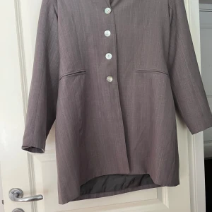 Grå kavaj - Säljer nu en fin grå kavaj pga att den inte passar längre. Bra skick som ny. Fint märke Pazzione. Kan komma överens om annat pris