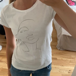 Vit topp med coolt tryck  - Jättesnygg topp med coolt tryck Använd fåtal gånger  Jättebra skick Är i barnstorlek L men jag har Xs-S i vanliga fall och den passar jättebra