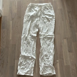 Vita linnebyxor - Säljer ett par vita linnebyxor. De är superbekväma och perfekta för varma sommardagar. Byxorna har en elastisk midja för extra komfort och en avslappnad passform. De är i bra skick och redo för en ny ägare!