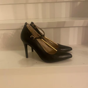 Svarta pumps - Svarta pumps med guld detaljer. Från Bianco! Använda vid ett tillfälle!