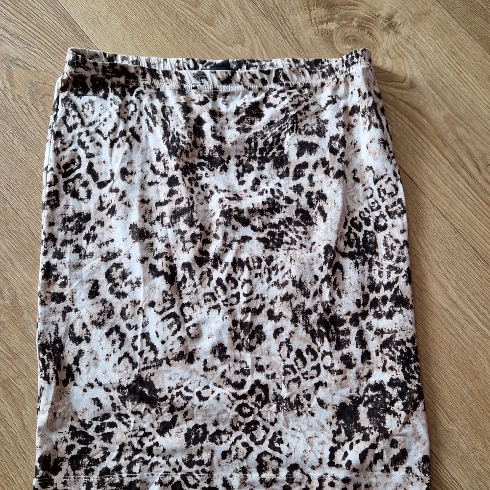 Säljer en superfin kjol från Lindex i storlek M. Den har ett coolt leopardmönster i svart och beige som verkligen sticker ut. Kjolen är perfekt för både vardag och fest, beroende på hur du stylar den. Materialet känns mjukt och skönt mot huden. Passar perfekt till en enkel topp eller en snygg blus!. Kjolar.